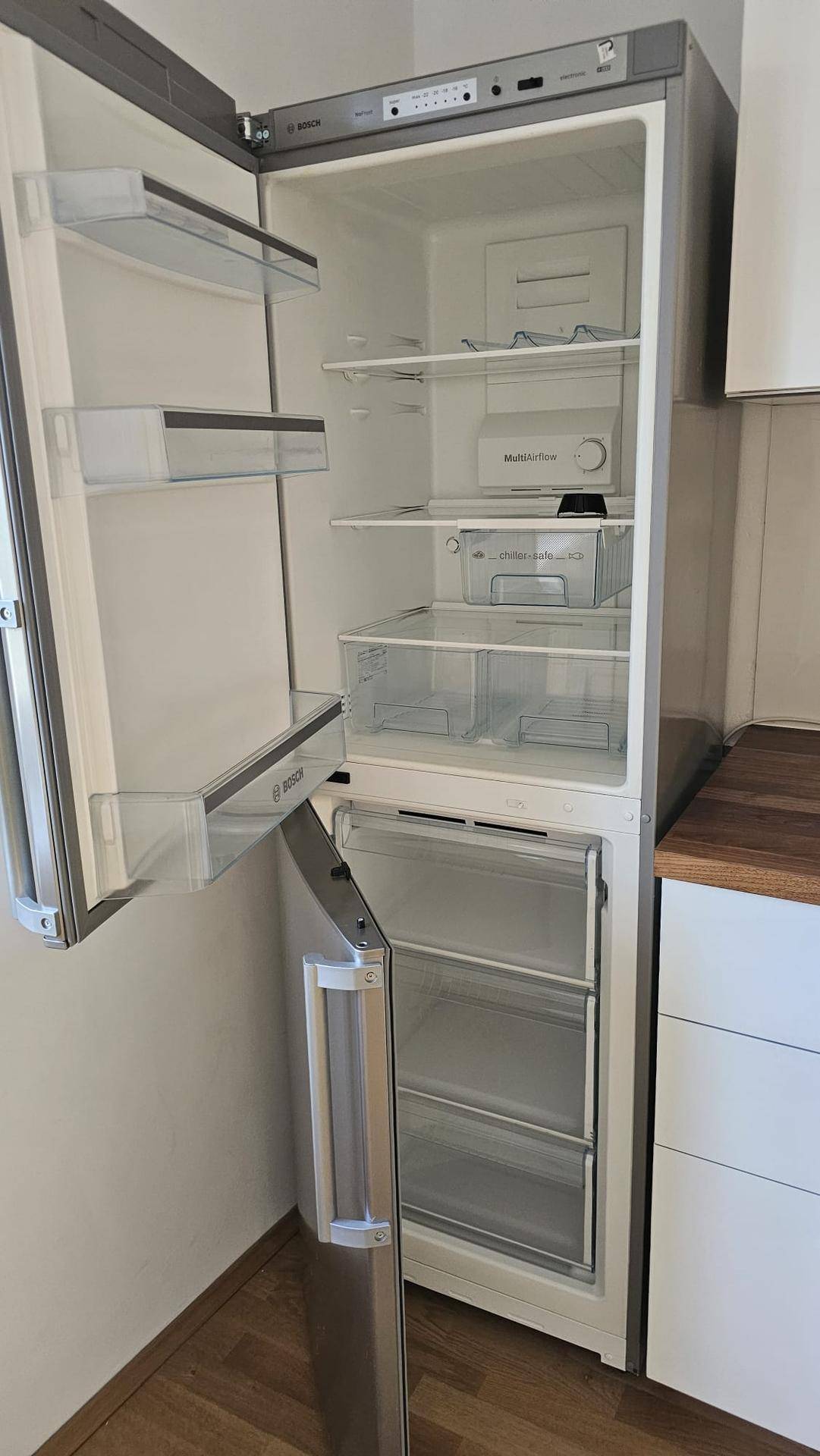 Offener Kühlschrank mit Gefrierfach, zeigt die gut organisierten Innenfächer und Ablagen.