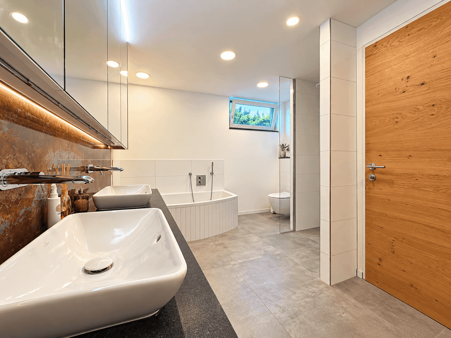 Geräumiges Badezimmer mit Doppelwaschbecken, Badewanne, begehbarer Dusche und Fenster.