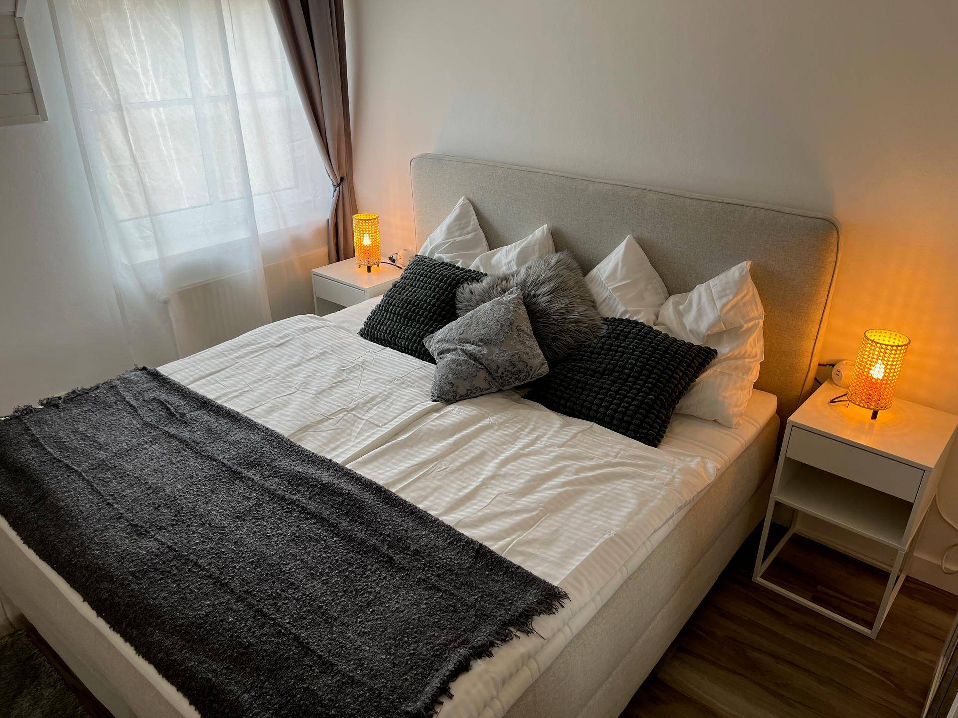 Gemütliches Schlafzimmer mit Doppelbett, zwei Nachttischen und warmem Licht.