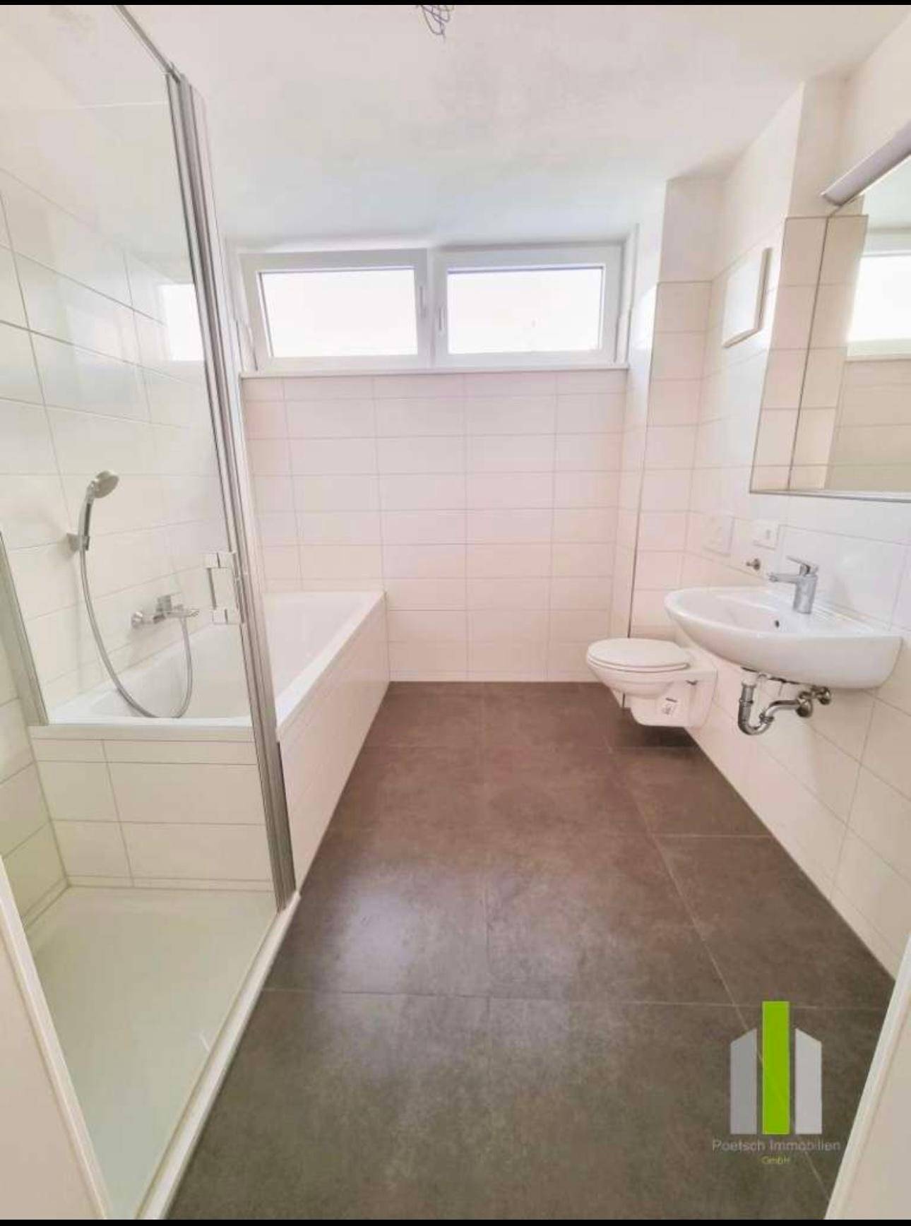 Modernes Badezimmer mit Badewanne, Dusche und Fenster, ausgestattet mit weißen Fliesen.