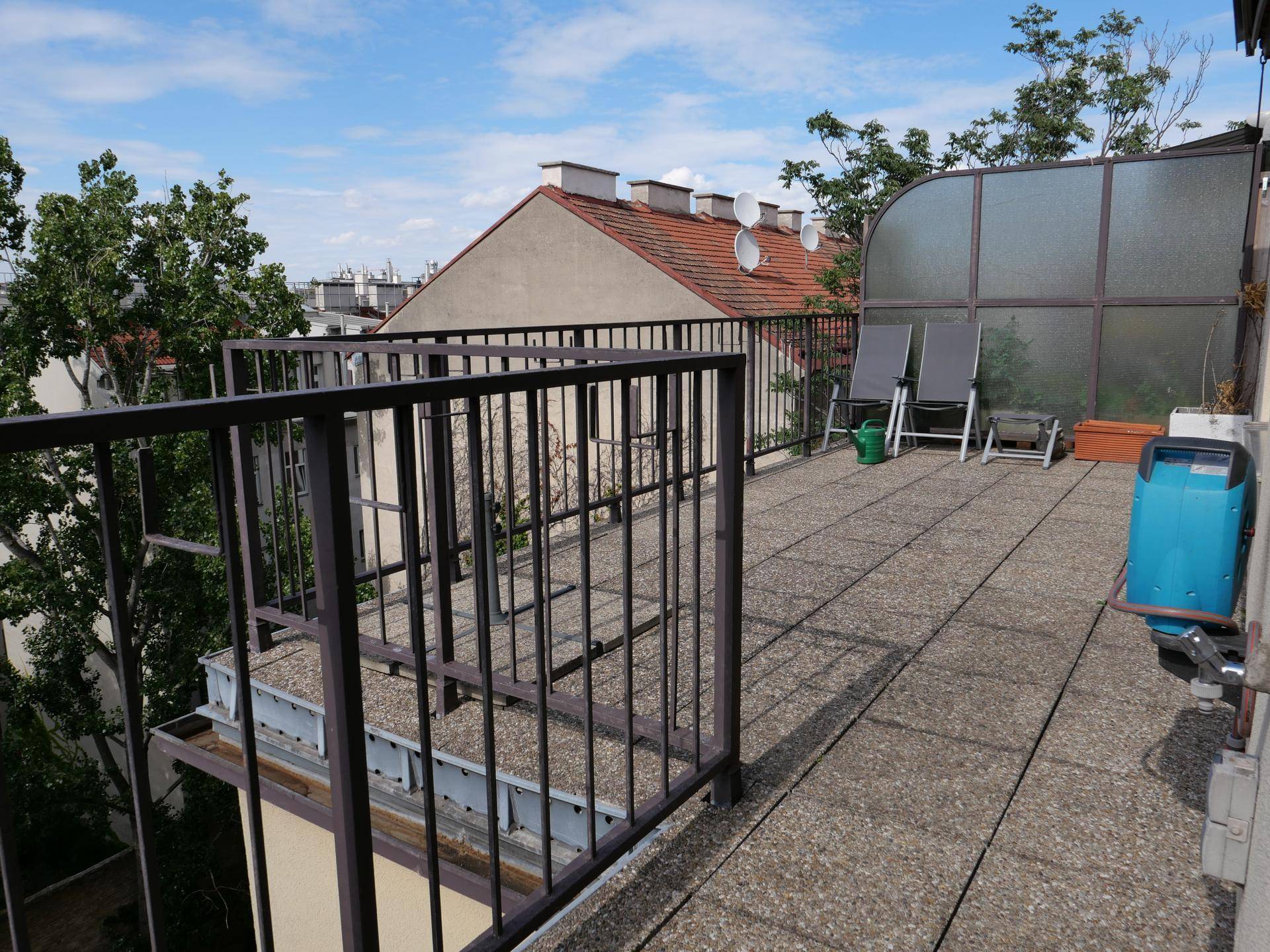 Geräumige Dachterrasse mit Liegestühlen und weitem Blick über die Stadt.