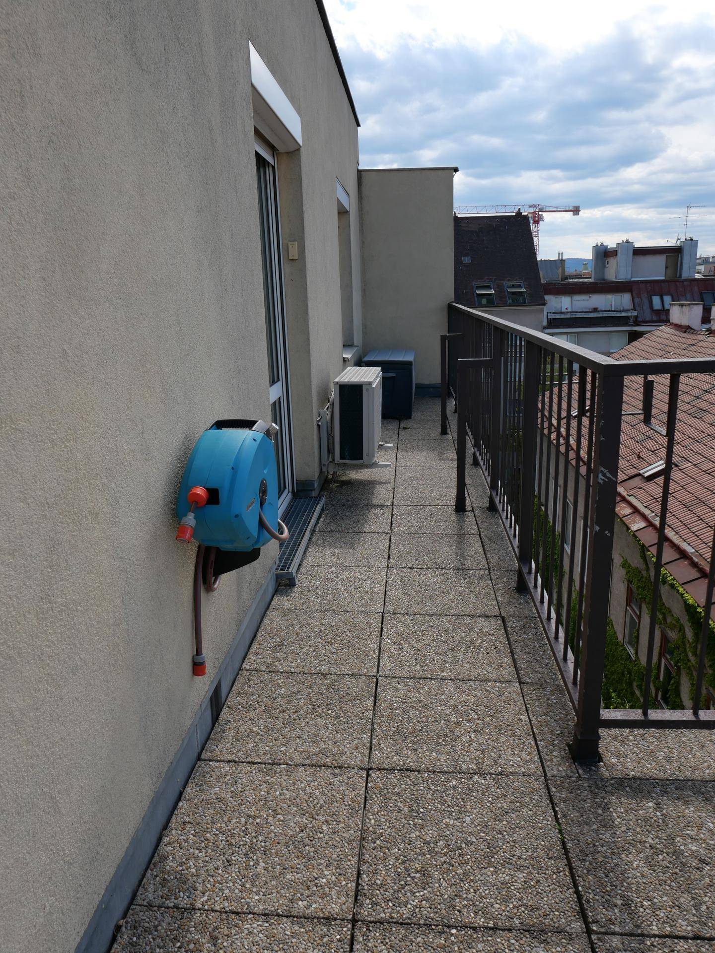 Schmaler Terrassenbereich mit Klimaanlage und Blick auf die umliegenden Dächer.