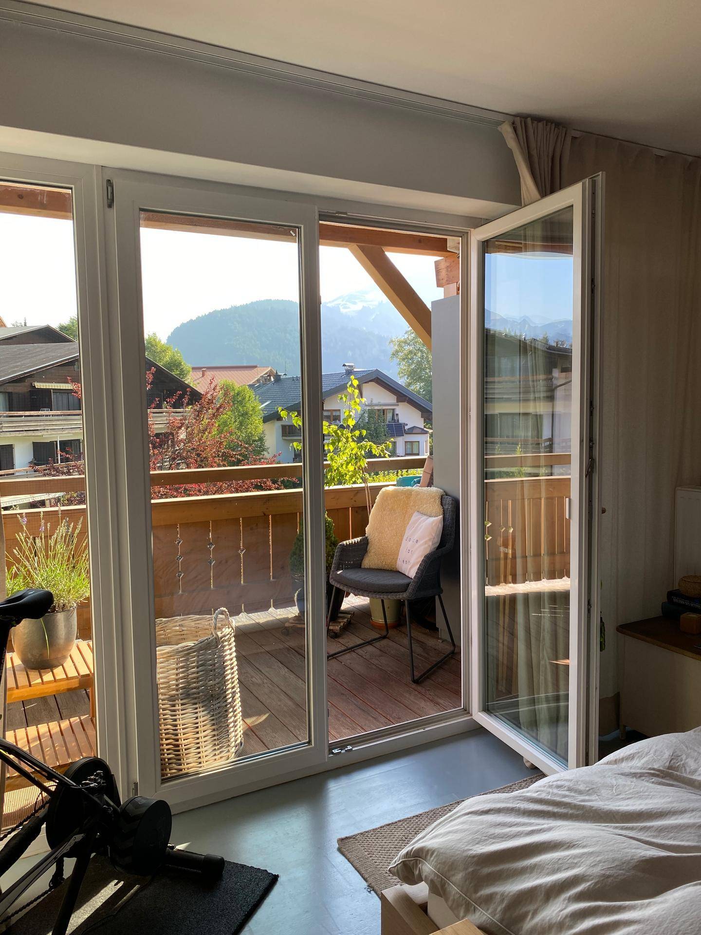 Helles Schlafzimmer mit Balkonzugang und Bergblick, ideal für entspannte Morgenstunden.
