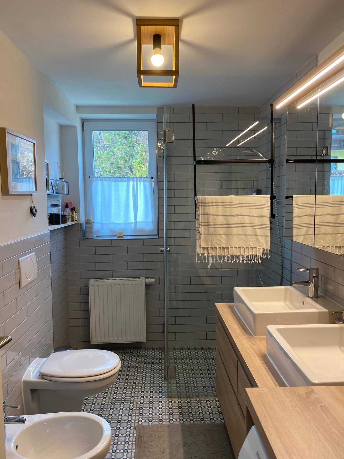 Modernes Badezimmer mit Doppelwaschbecken, ebenerdiger Dusche und Fenster.