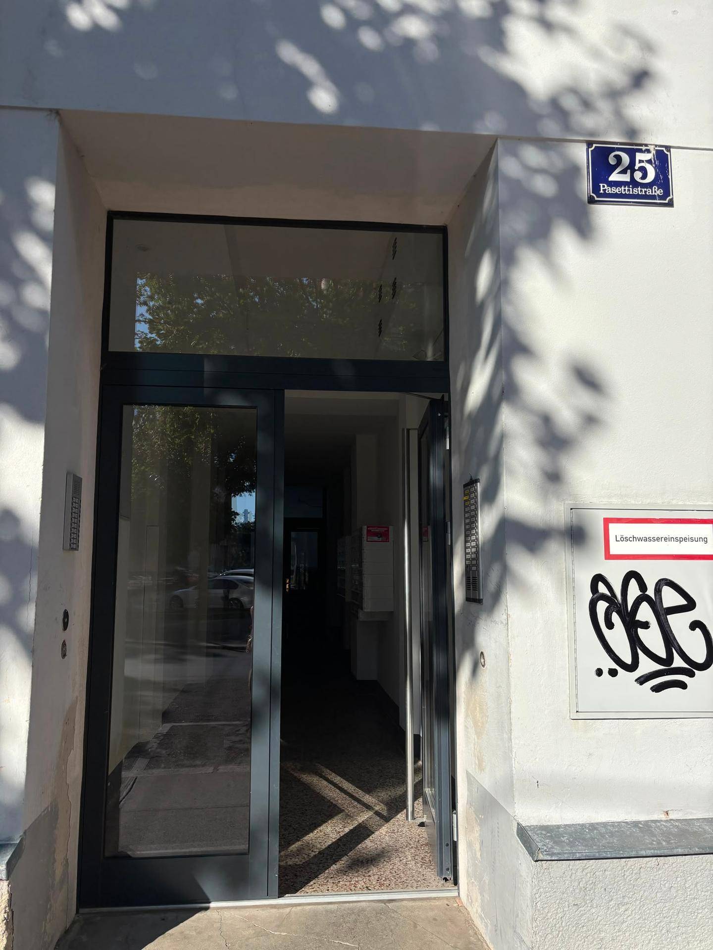 Haupteingang eines Gebäudes mit Glastür und der Hausnummer 25 an der Pusetistraße.