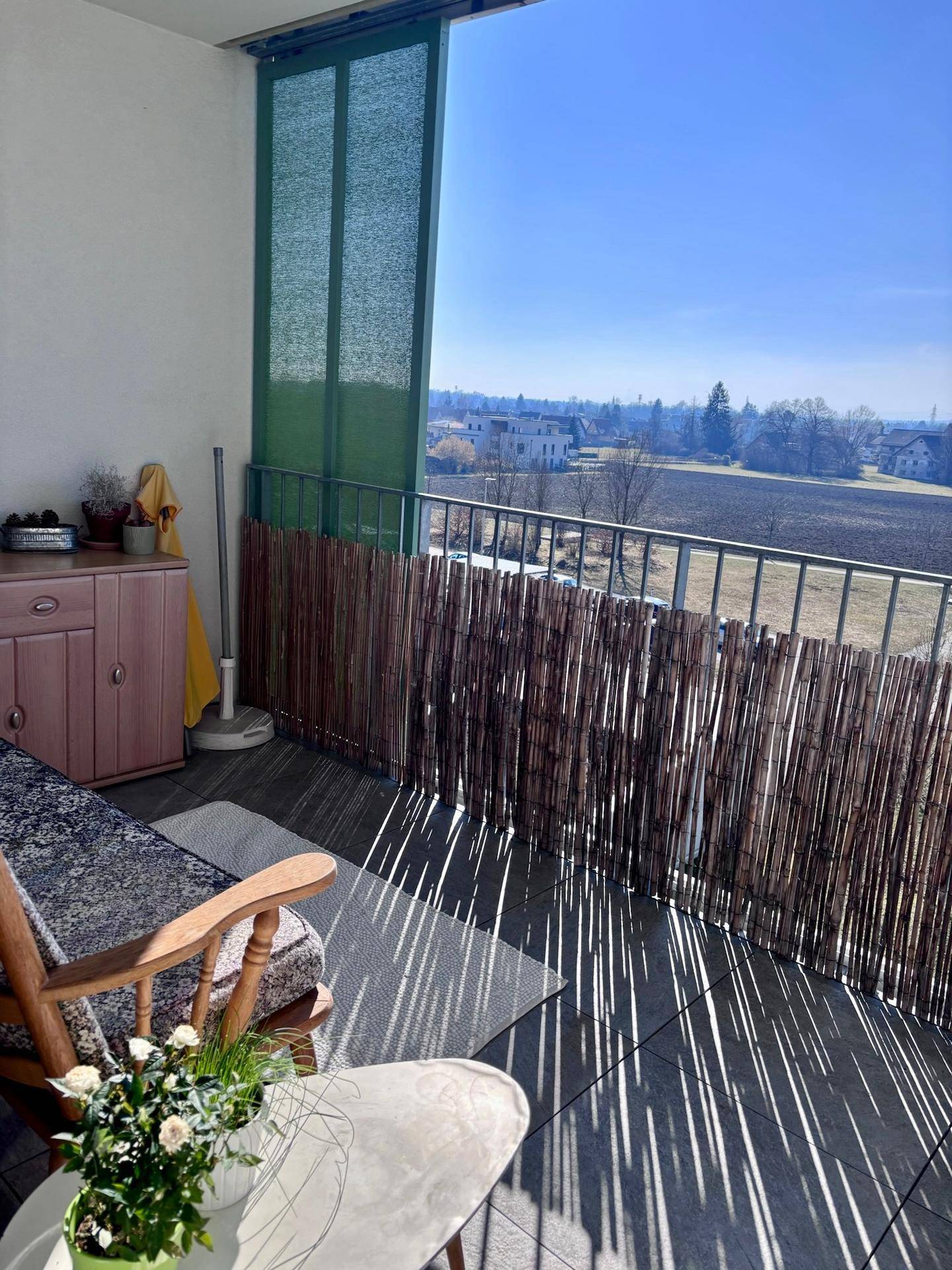 Sonniger Balkon mit Sitzgelegenheiten und weitem Blick über die Landschaft.