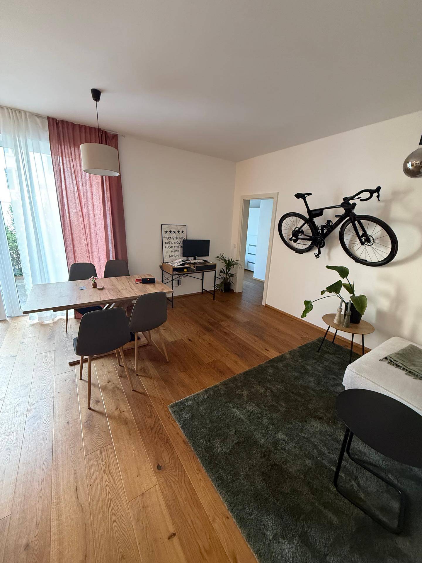 Geräumiger Wohn-Essbereich mit Holzboden, großem Esstisch und moderner Dekoration.