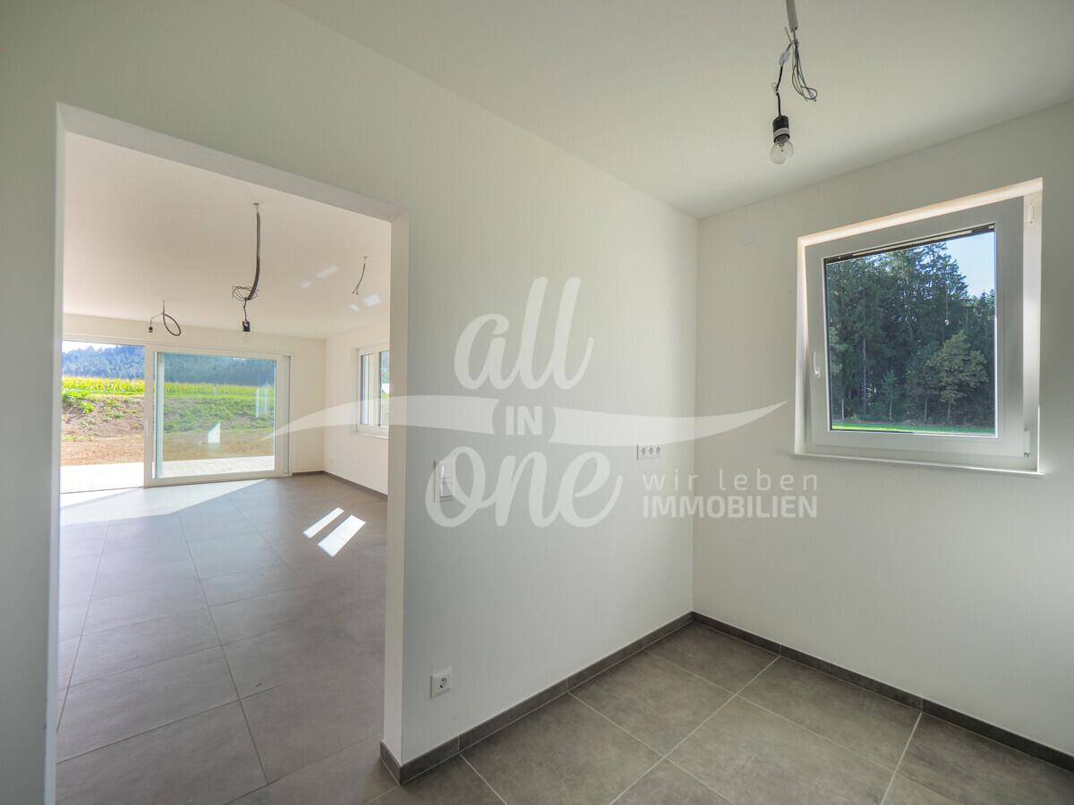 Helles Zimmer mit Fliesenboden und Fenster, ideal als Büro oder Gästezimmer nutzbar.