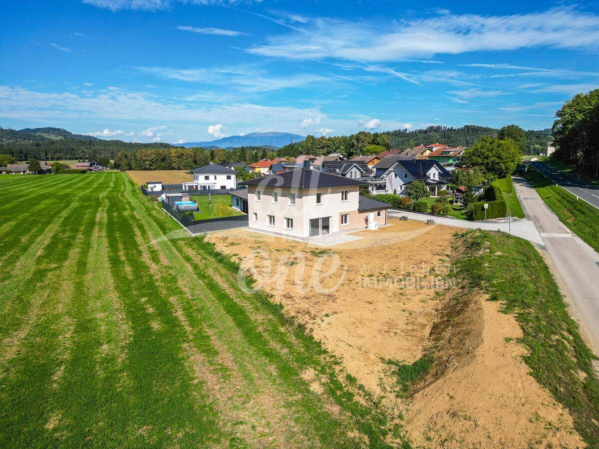 Weitläufige Luftaufnahme des Hauses in ländlicher Umgebung mit angrenzender Straße und Nachbarschaft.