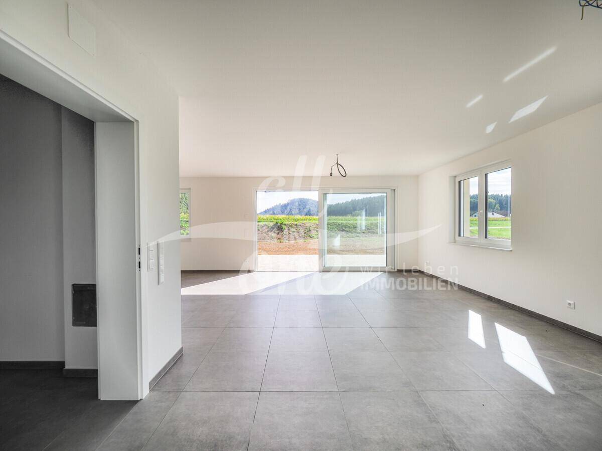 Helles Wohnzimmer mit Fliesenboden und Zugang zur Terrasse, bereit zur individuellen Gestaltung.