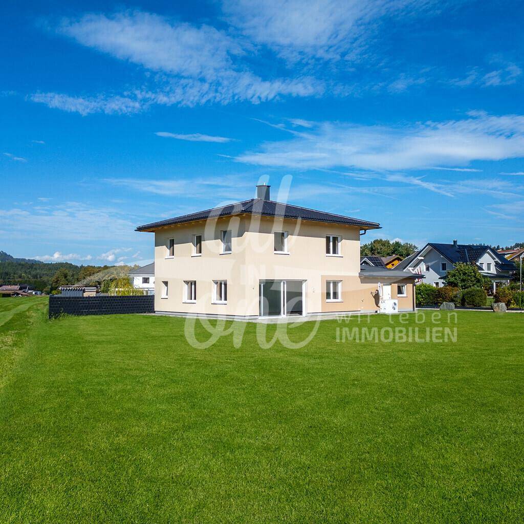 Neues Einfamilienhaus mit frisch angelegtem Rasen und weitem Blick in die Natur.