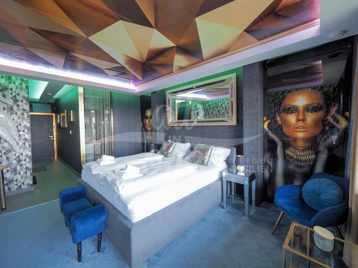Elegantes Schlafzimmer mit Doppelbett, dekorativem Spiegel und künstlerischer Wandgestaltung.