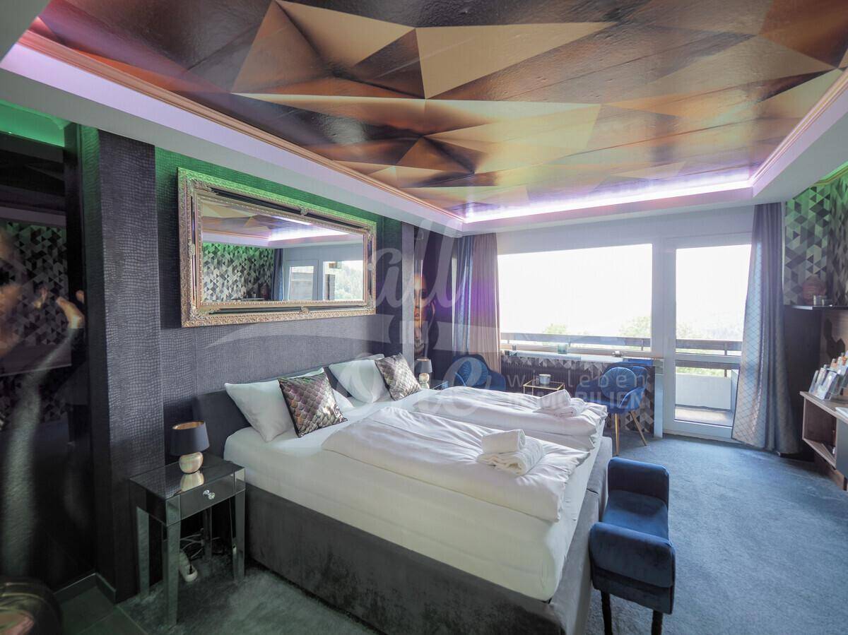Stilvolles Schlafzimmer mit Doppelbett, Spiegel und kreativer Deckenbeleuchtung sowie Wandtapete.