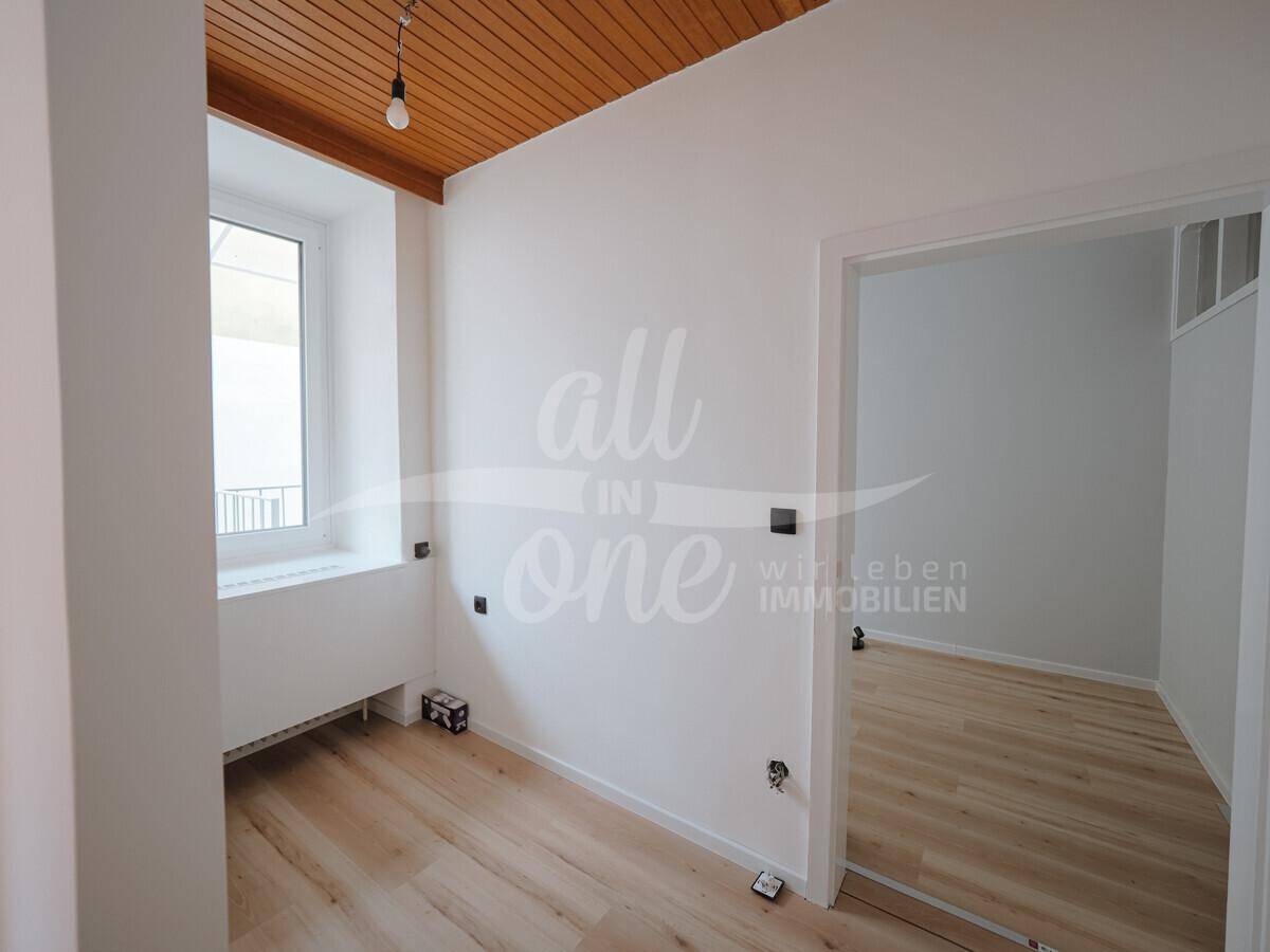Helles Zimmer mit Holzdecke und Fenster, ideal als Schlaf- oder Arbeitszimmer nutzbar.