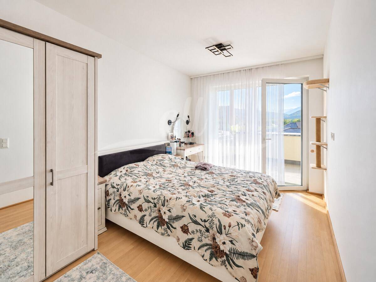 Gemütliches Schlafzimmer mit Doppelbett, Kleiderschrank und direktem Zugang zum Balkon.