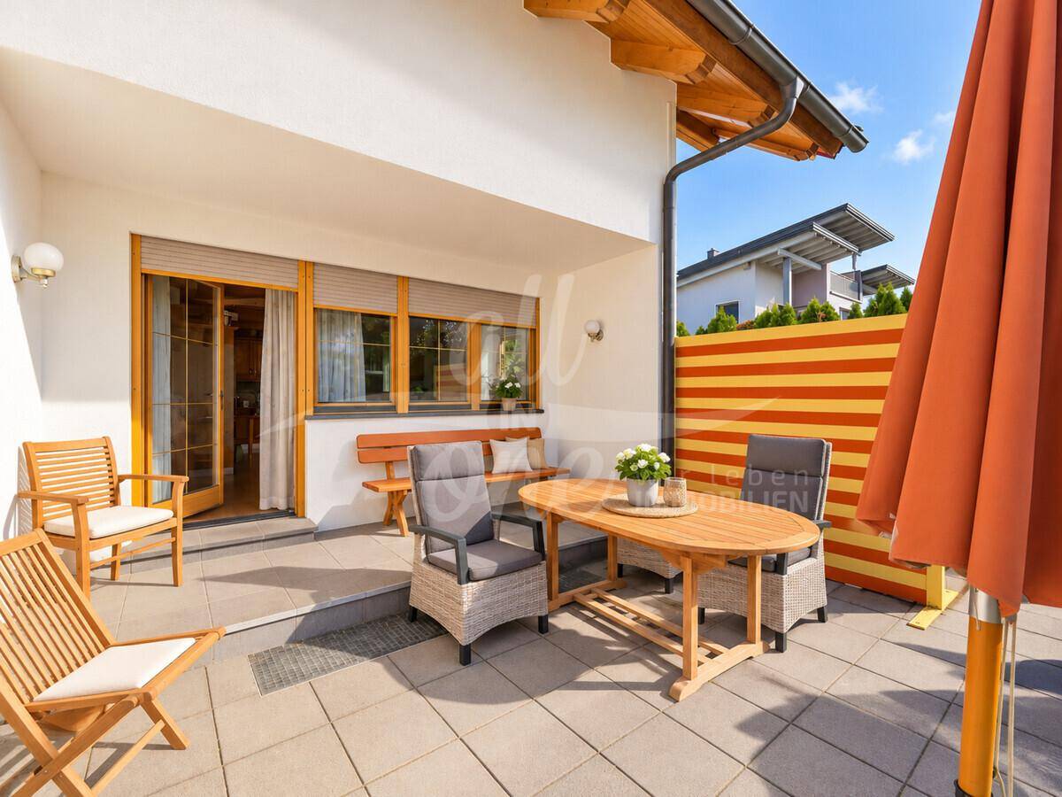 Gemütliche Terrasse mit Gartenmöbeln und Sonnenschirm, ideal für entspannte Stunden im Freien.