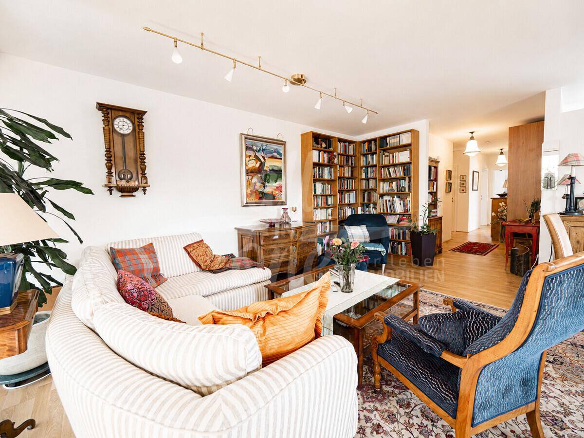 Gemütliches Wohnzimmer mit großem Sofa, traditionellem Teppich und einer umfangreichen Bücherwand.