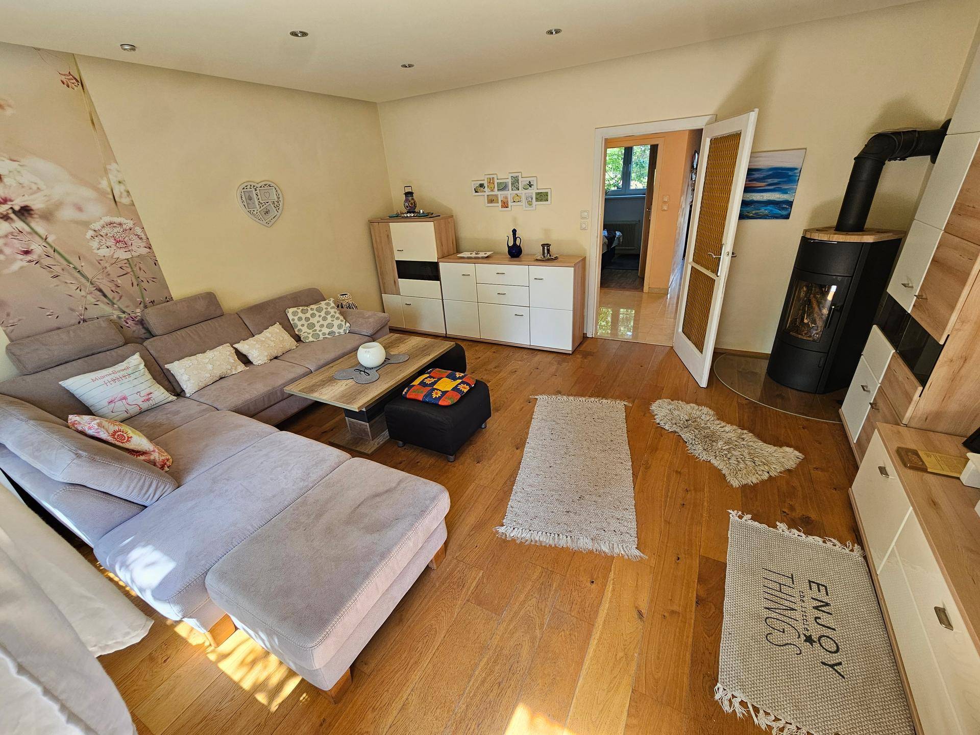 Gemütliches Wohnzimmer mit Holzboden, modernem Kaminofen und stilvollen Möbeln.