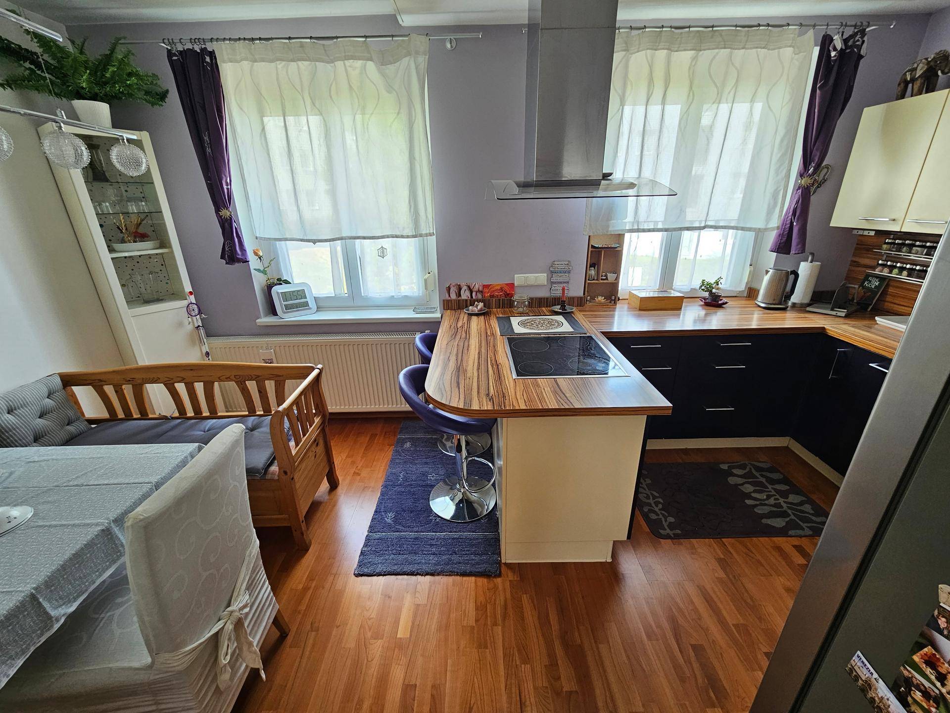 Moderne Küche mit Kochfeld auf der Halbinsel, Dunstabzugshaube und Holz-Arbeitsplatten.