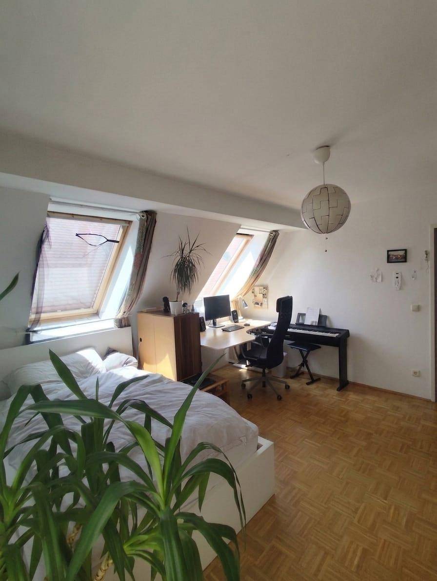 Geräumiges Schlafzimmer mit Arbeitsplatz, Dachfenstern und viel Tageslicht.