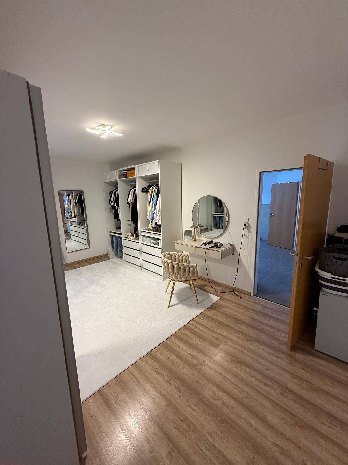 Geräumiges Ankleidezimmer mit integrierten Spiegelschränken und stilvollem Schminkbereich.