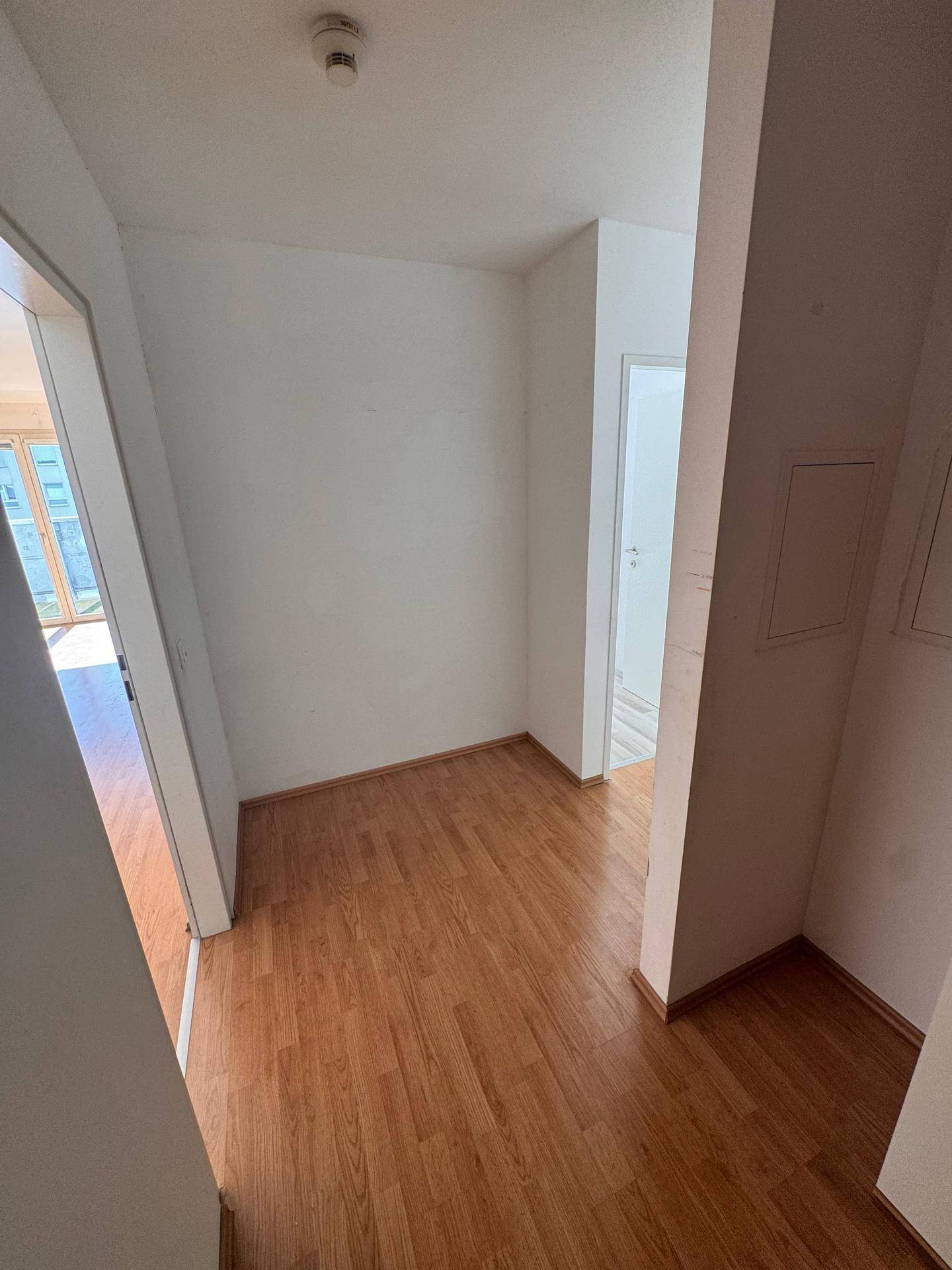 Heller Flur mit Laminatboden und Zugang zu weiteren Räumen der Wohnung.