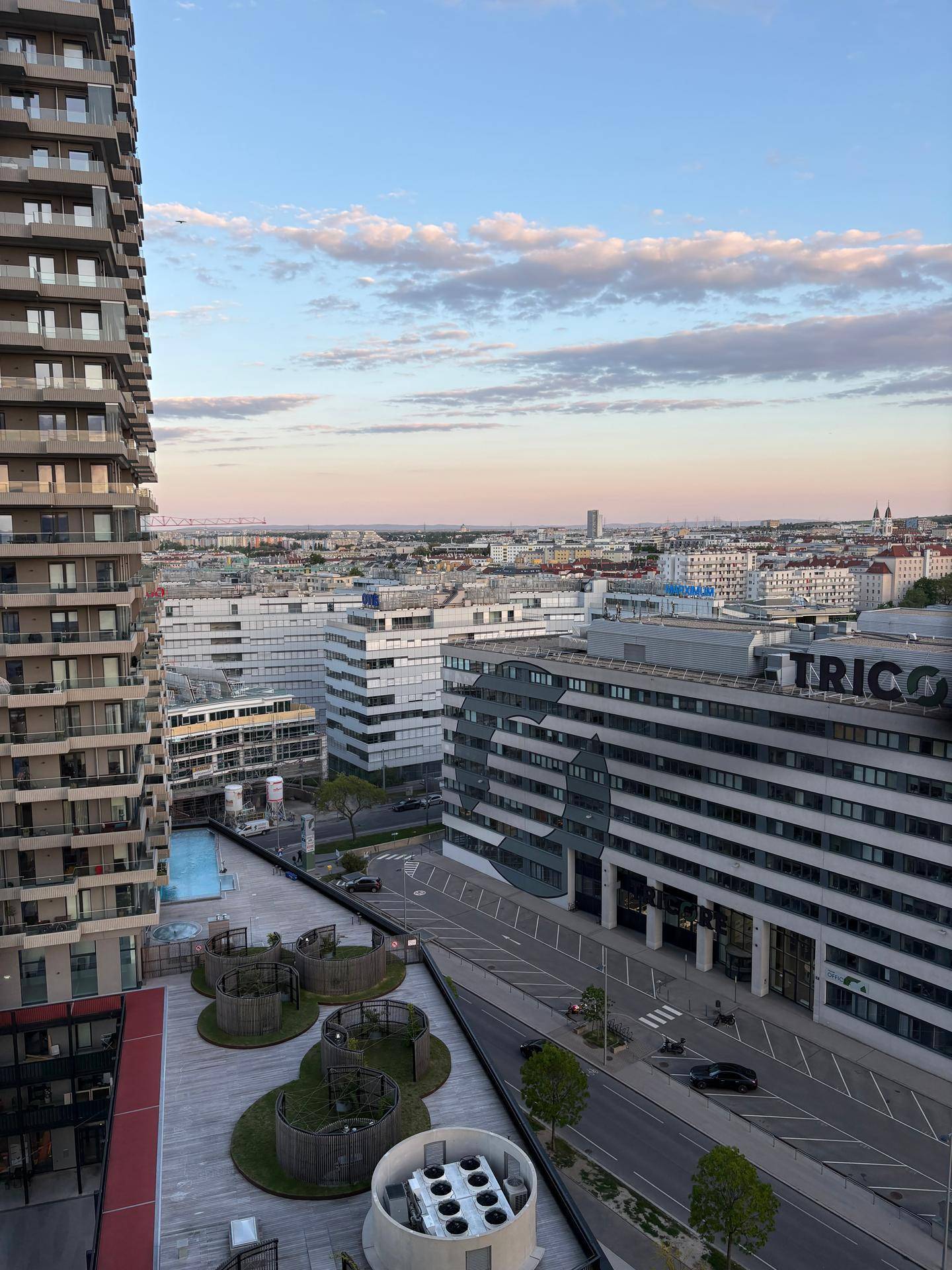 Panoramablick über die Stadt mit modernen Gebäuden und einem Poolbereich.