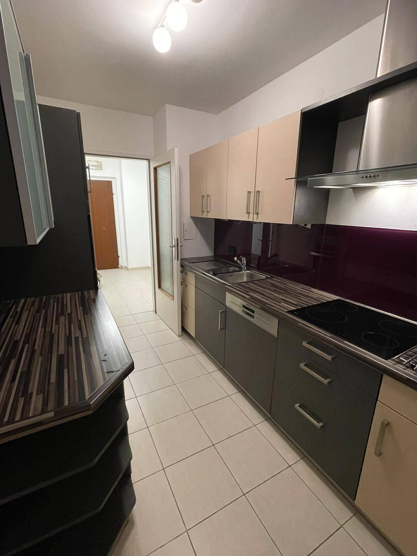 Funktionale Küche mit Fliesenboden und direktem Zugang zum Flur der Wohnung.