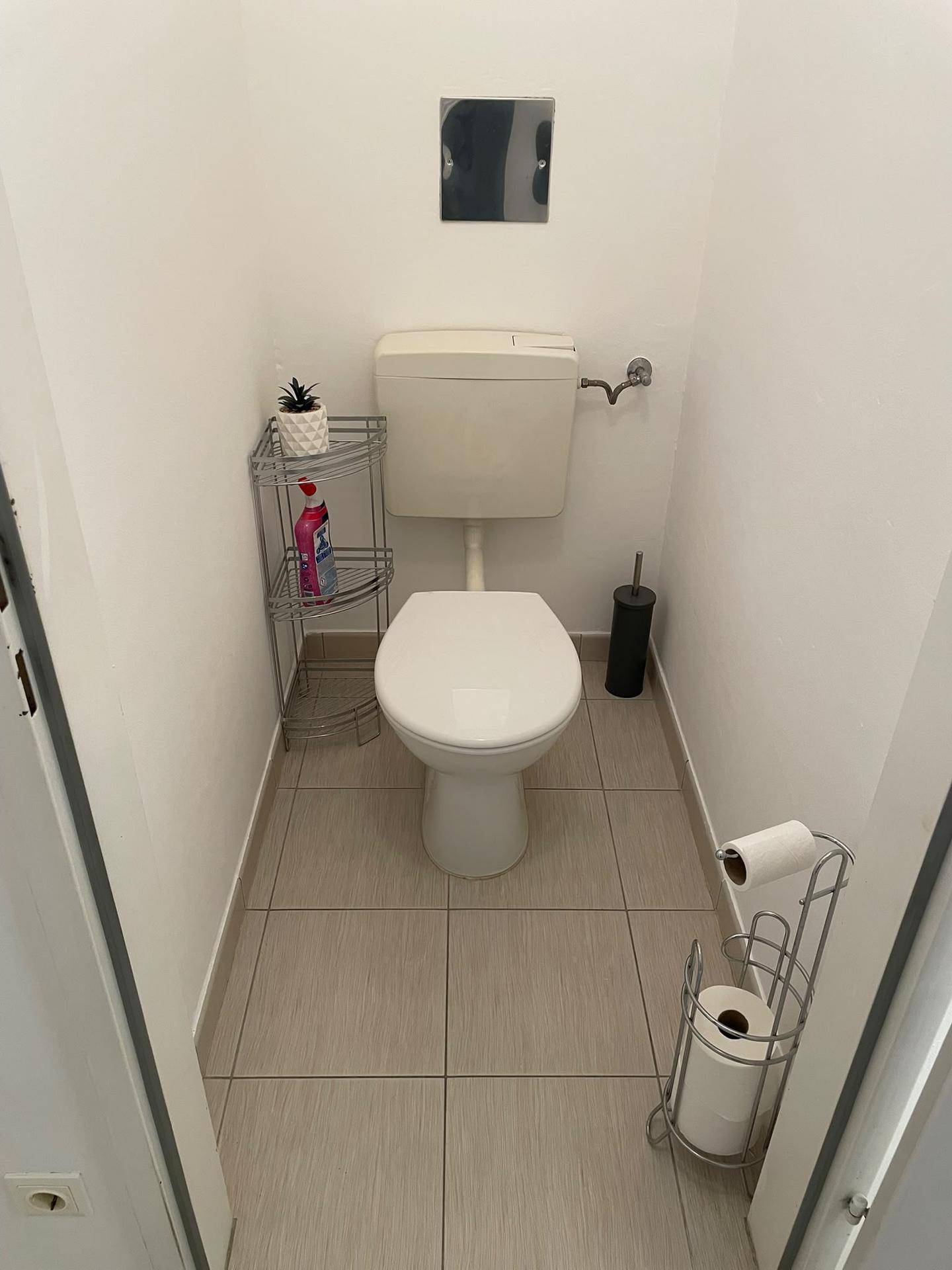 Separates WC mit Toilette und Fliesenboden, ausgestattet für Gäste.