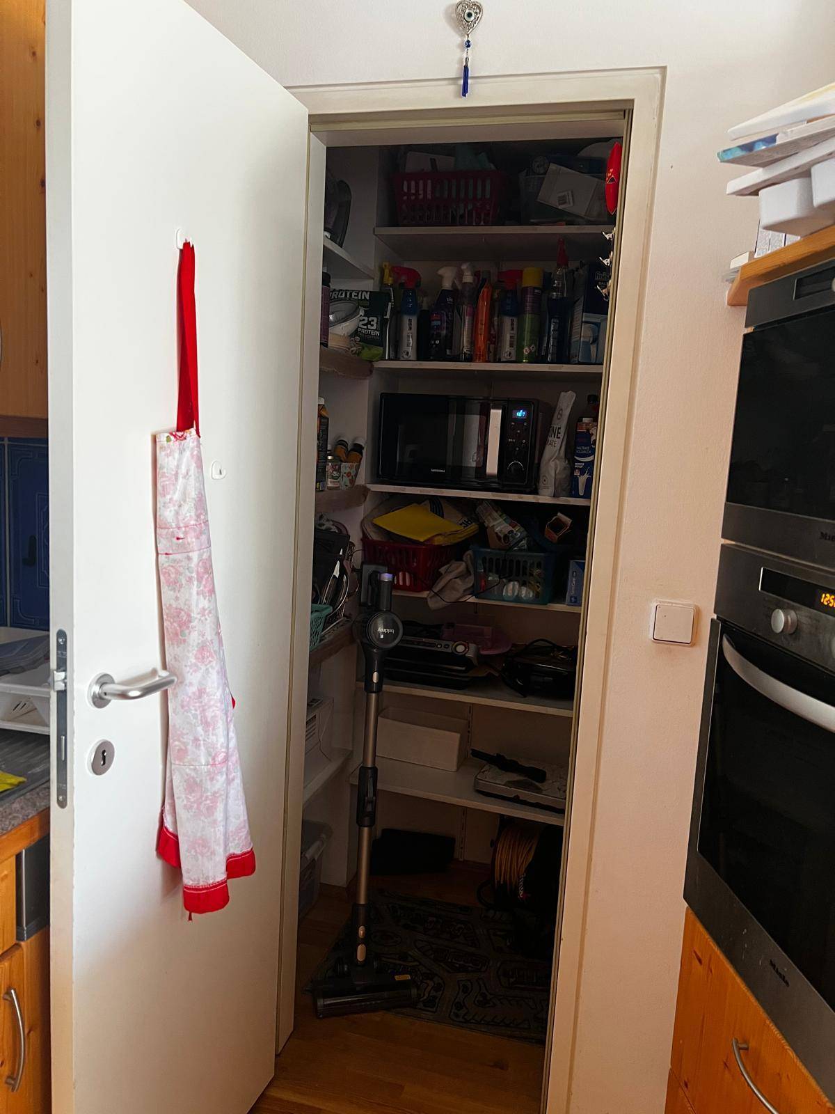 Praktische Speisekammer mit Regalen voller Vorräte und Haushaltsgegenständen für zusätzlichen Stauraum.