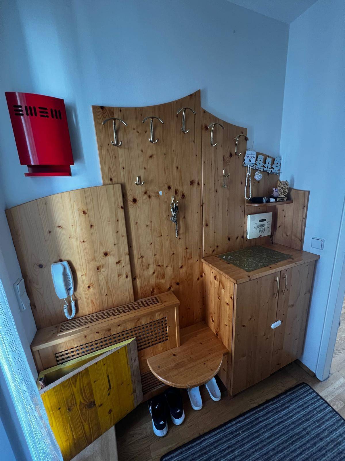 Rustikale Holzmöbel im Flur mit Garderobe, kleiner Sitzbank und praktischem Stauraum.