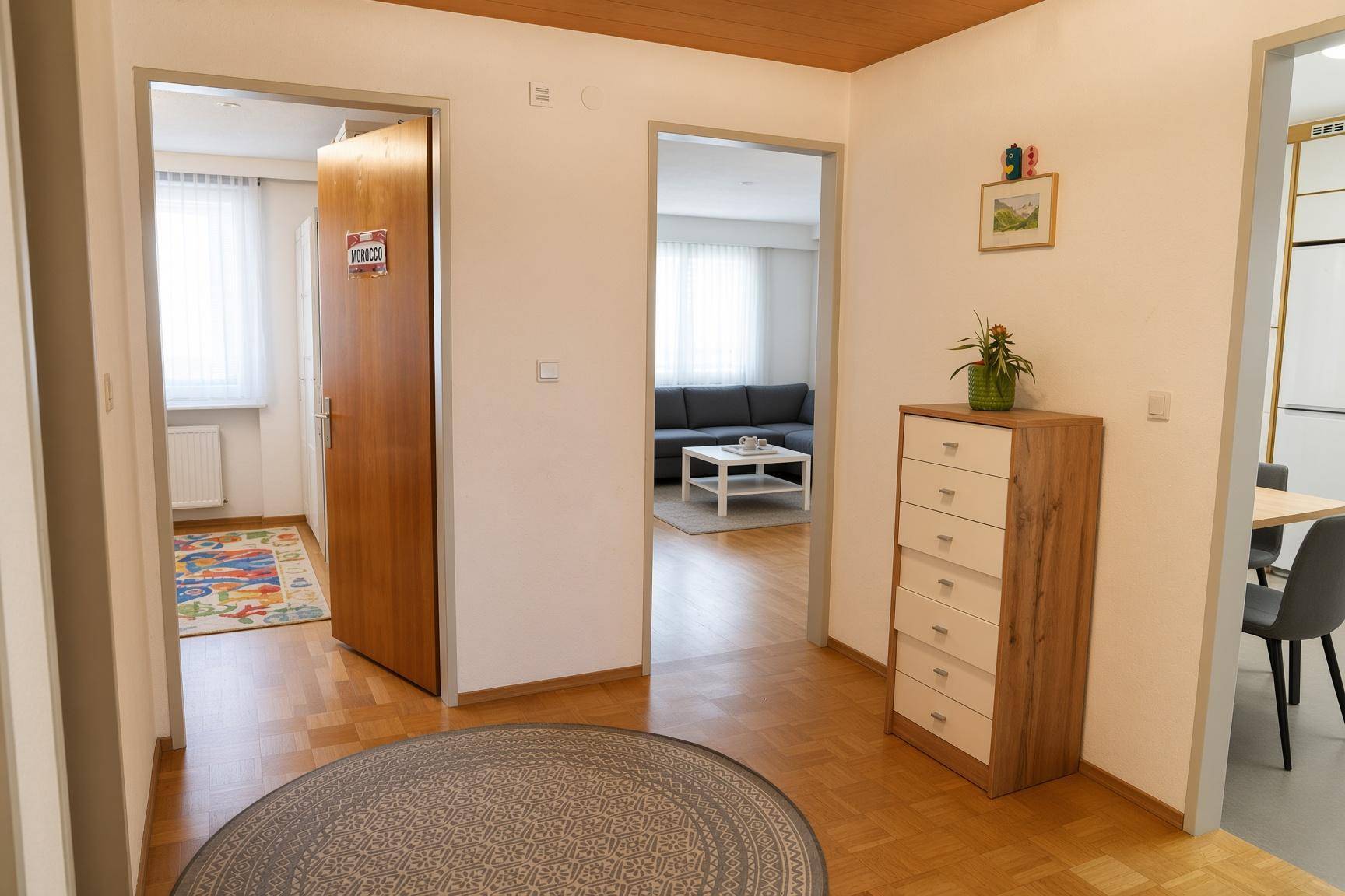 Heller Flur mit Holzboden und Zugang zu verschiedenen Zimmern der Wohnung.