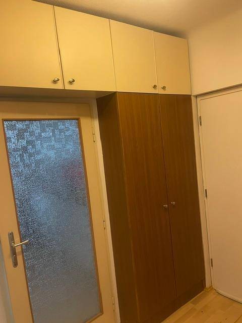 Flur mit Einbauschrank und Tür mit Milchglas, bietet praktischen Stauraum.