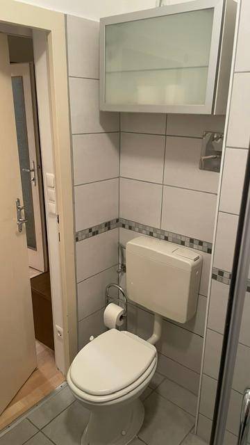 Kleines WC mit Wandtoilette und Spiegelschrank, funktional und sauber.