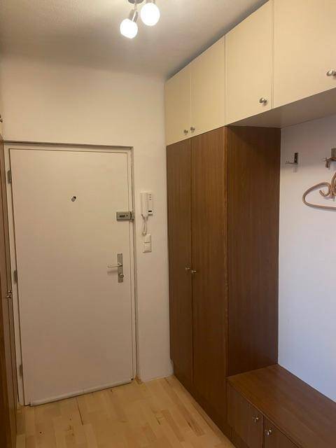 Eingangsbereich mit Garderobenschrank und Sicherheitstür, funktional gestaltet.