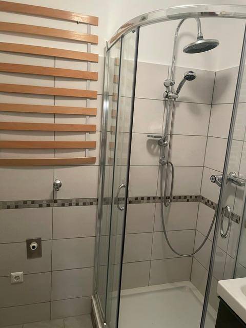 Modernes Badezimmer mit Duschkabine, Regendusche und weißen Fliesen.