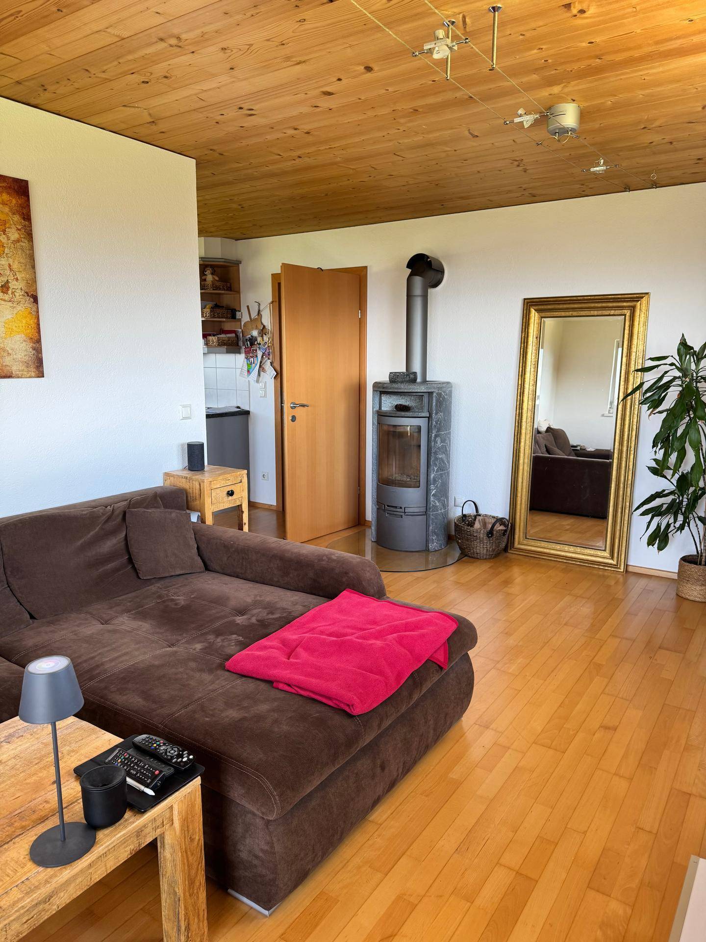 Gemütliches Wohnzimmer mit Kaminofen, großem Sofa und Holzdecke, ideal für entspannte Abende.