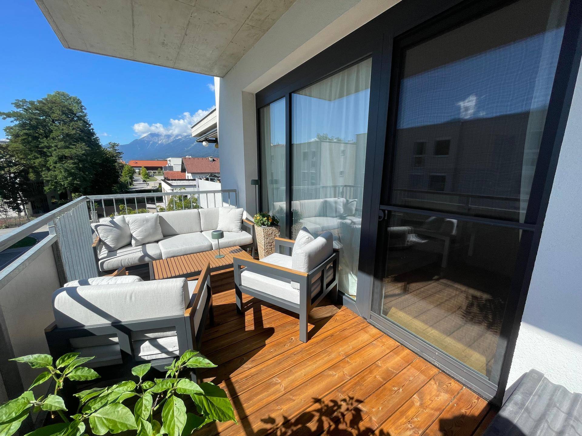 Geräumiger Balkon mit Sitzgelegenheiten und weitem Blick auf die umliegende Berglandschaft.
