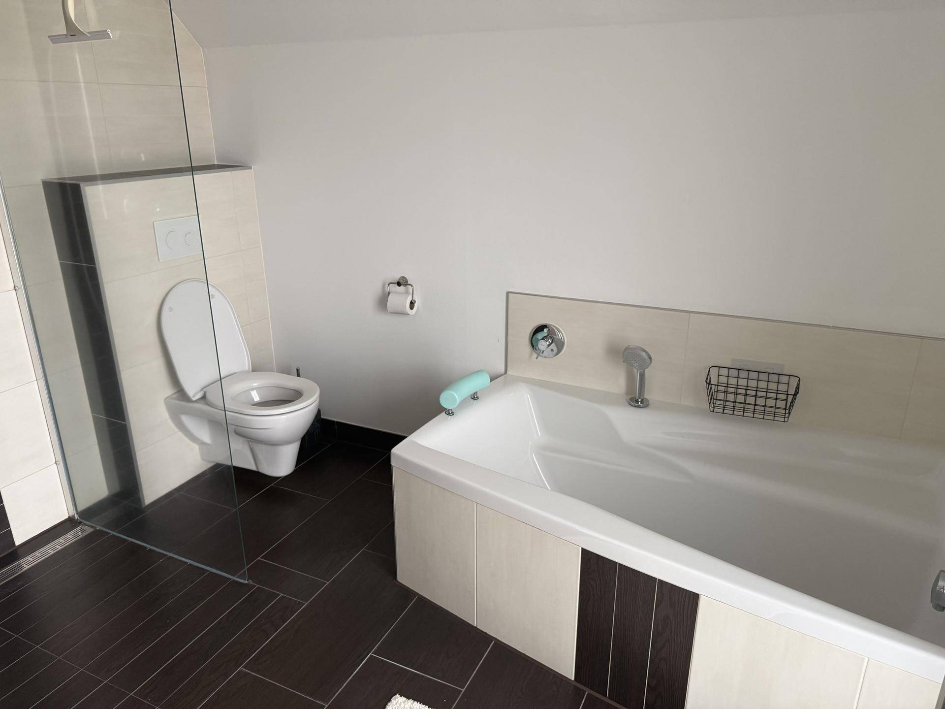 Modernes Badezimmer mit Badewanne, wandhängendem WC und begehbarer Dusche.