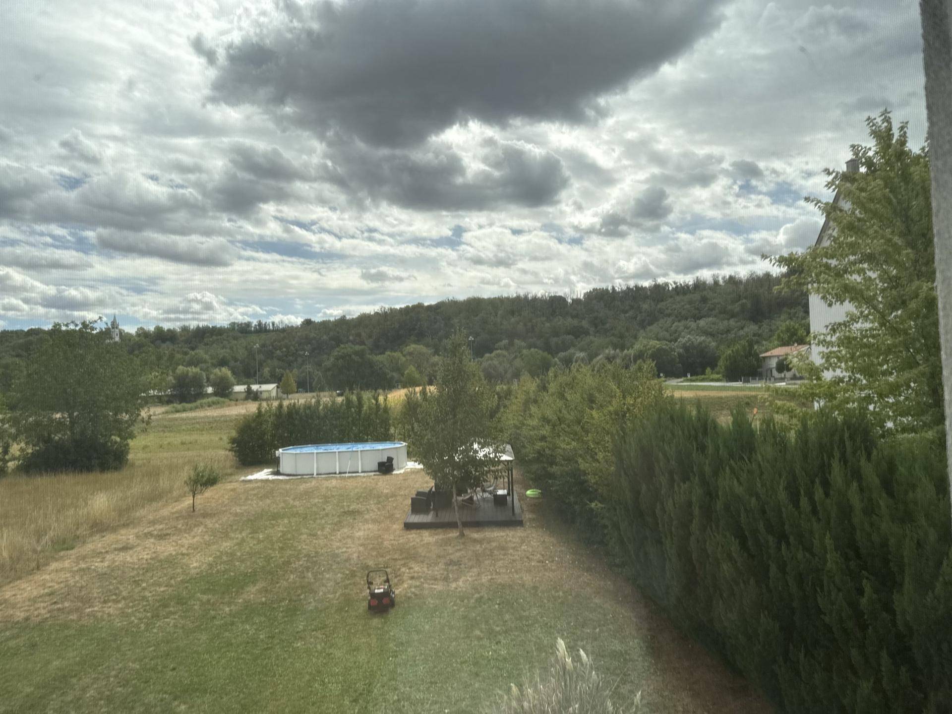 Weitläufiger Garten mit Rasenfläche, oberirdischem Pool und Blick auf die umliegende Landschaft.