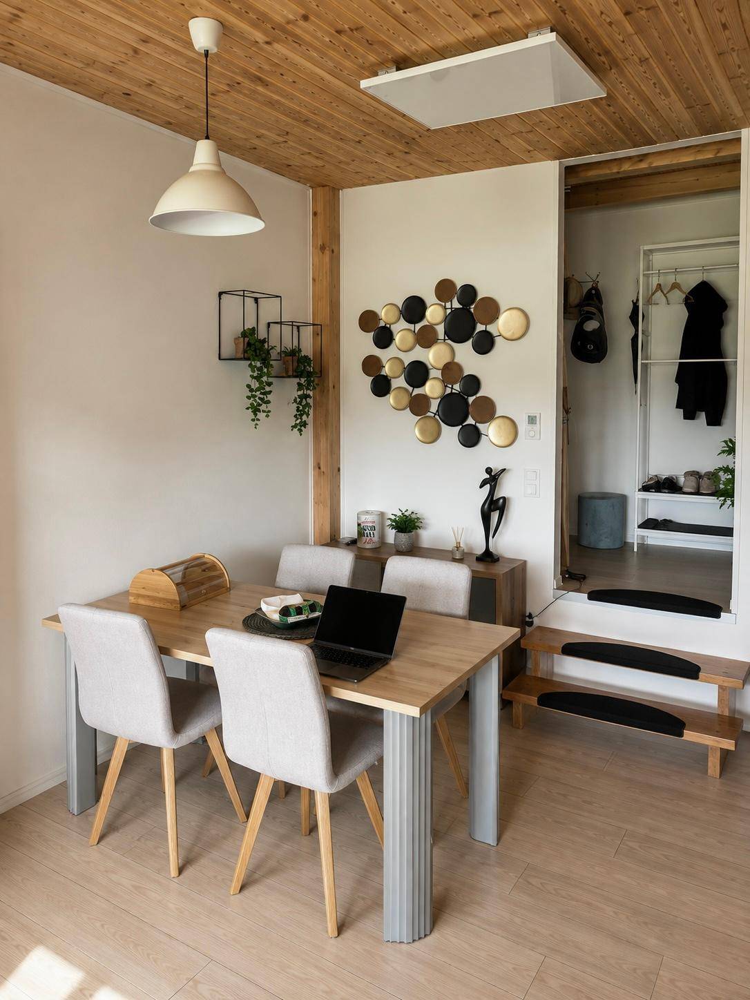 Gemütlicher Essbereich mit Holztisch, modernen Stühlen und dekorativer Wandgestaltung.