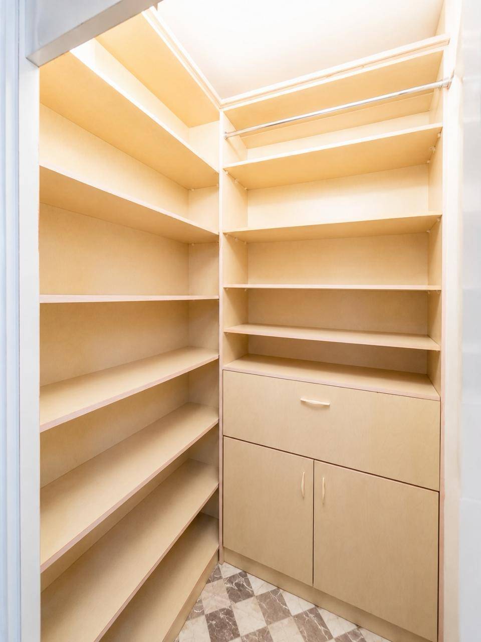 Begehbarer Kleiderschrank mit vielen Regalen, Schubladen und Kleiderstange.