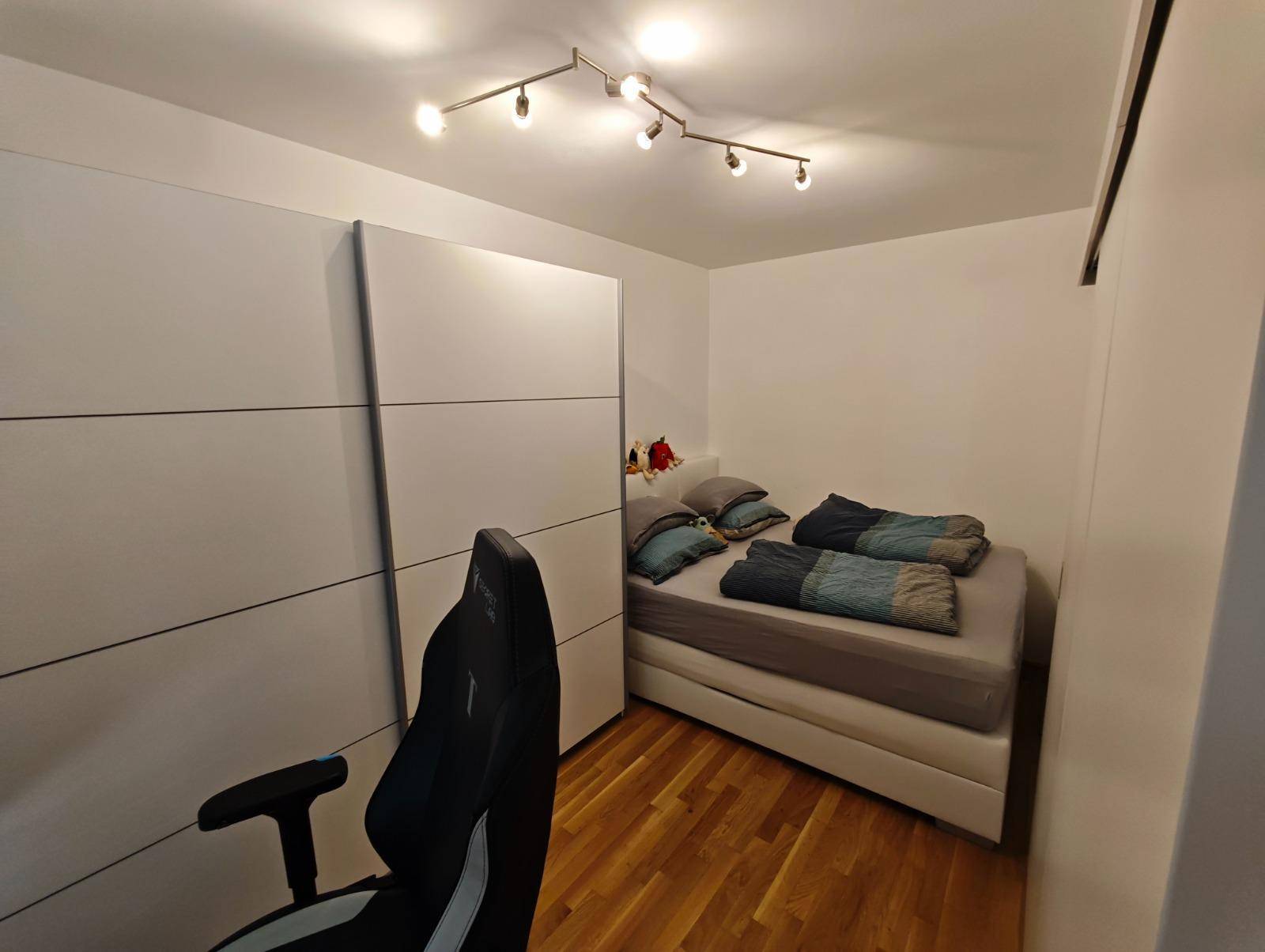 Gemütliches Schlafzimmer mit Doppelbett und großem, modernem Kleiderschrank.
