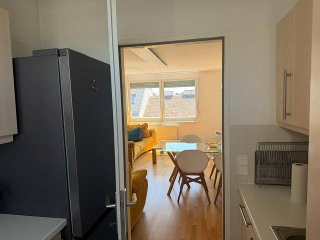Blick von der Küche in den offenen Wohn-Essbereich mit großem Kühlschrank.