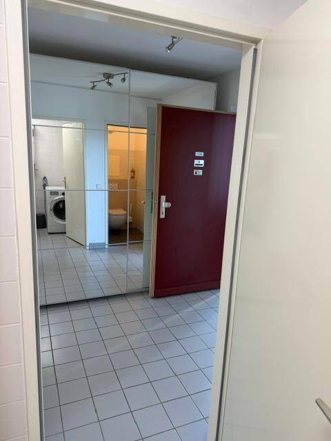 Eingangsbereich mit Spiegelschrank und Blick auf die Türen zum WC und Badezimmer.