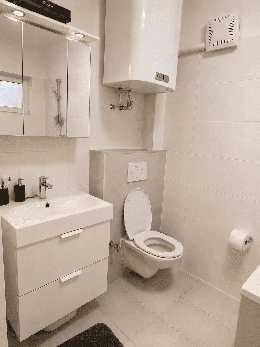 Modernes Badezimmer mit Waschbecken, wandhängendem WC und Spiegelschrank.