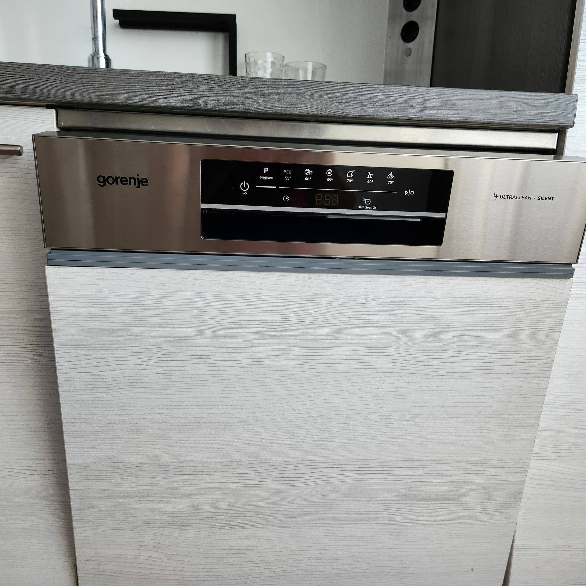 Nahaufnahme des integrierten Geschirrspülers der Marke Gorenje in der modernen Küche.