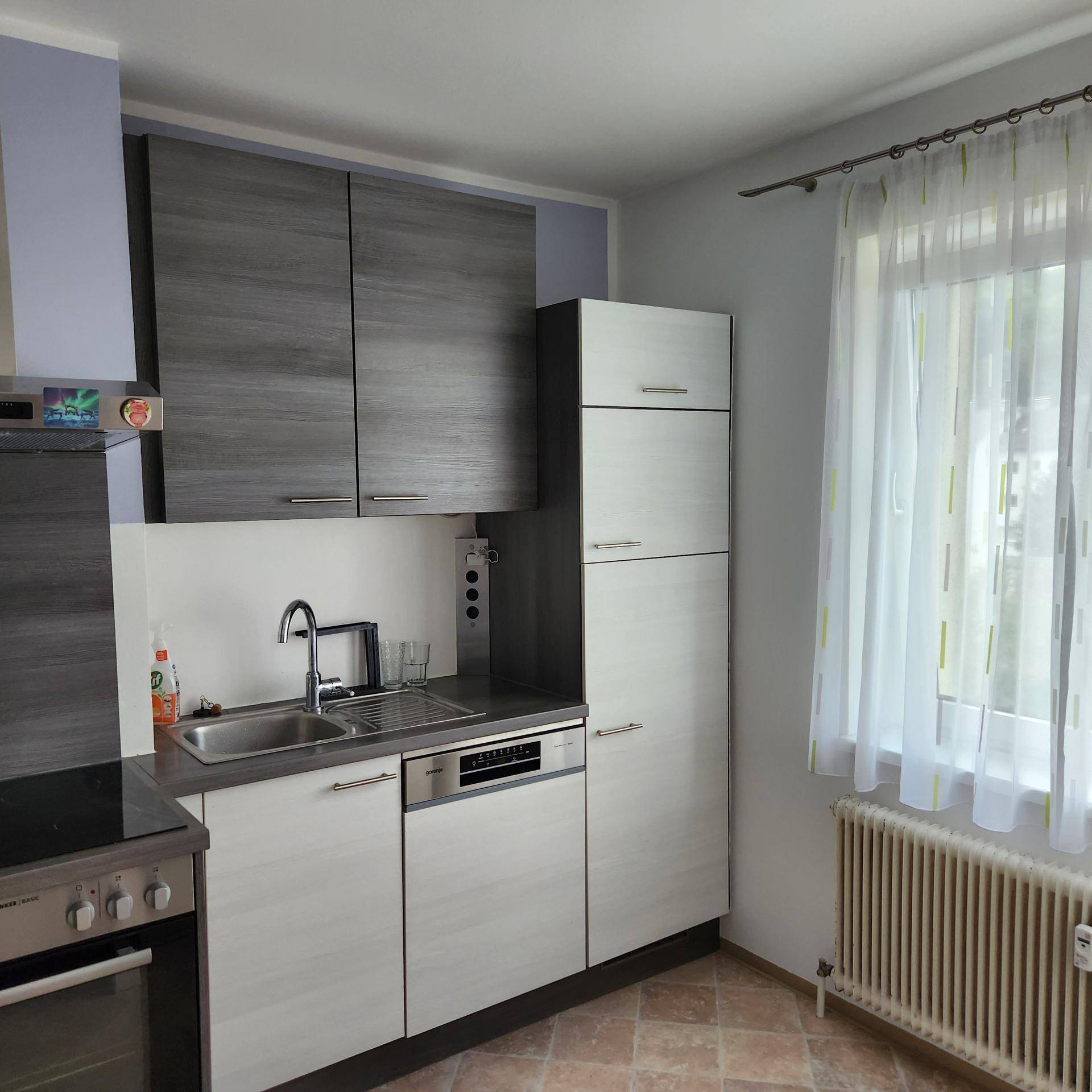 Funktionale Küche mit Spüle, Geschirrspüler und einem Fenster für natürliches Licht.