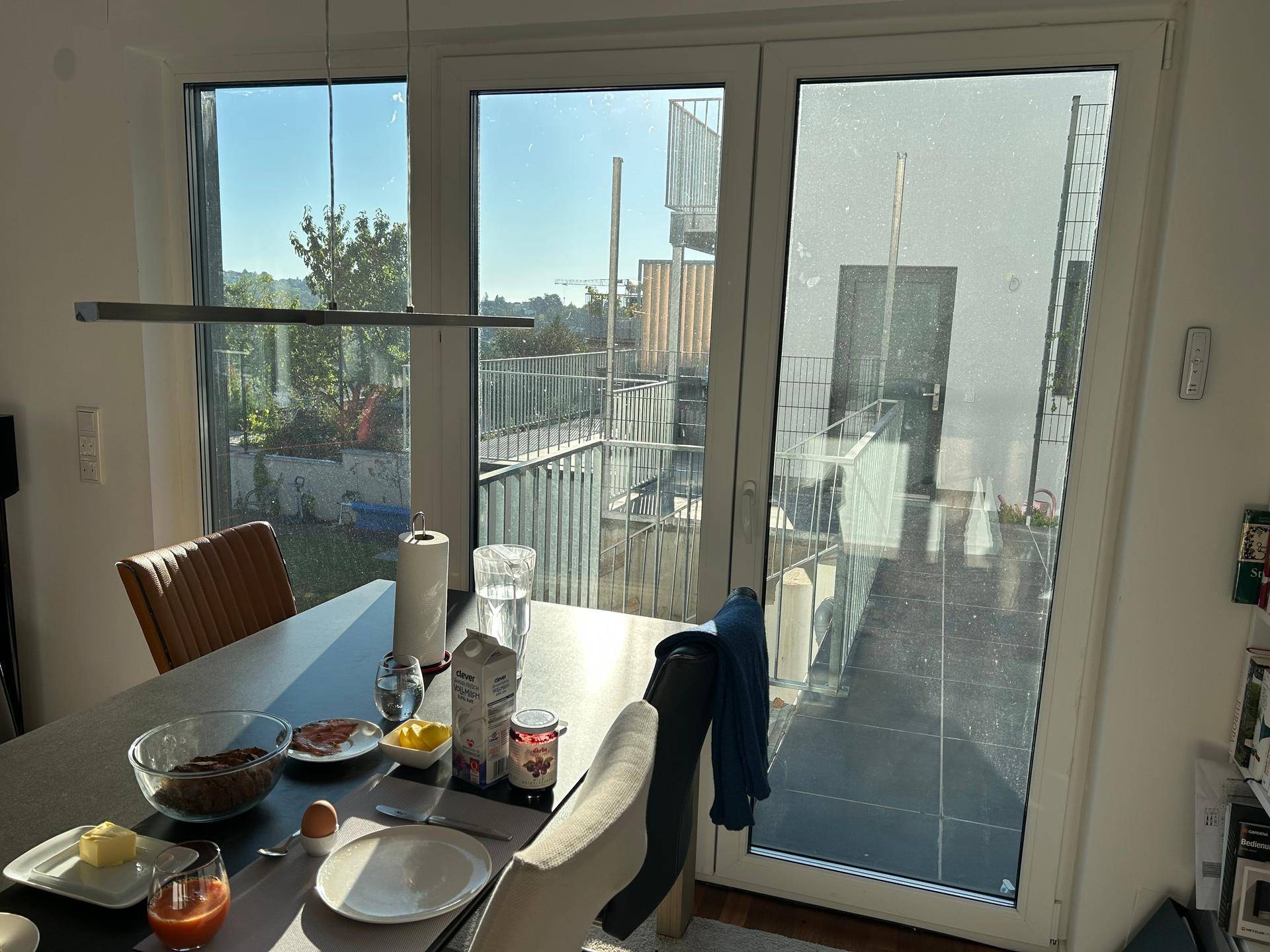 Frühstückstisch am Fenster mit Blick auf die Außenterrasse und die Umgebung.