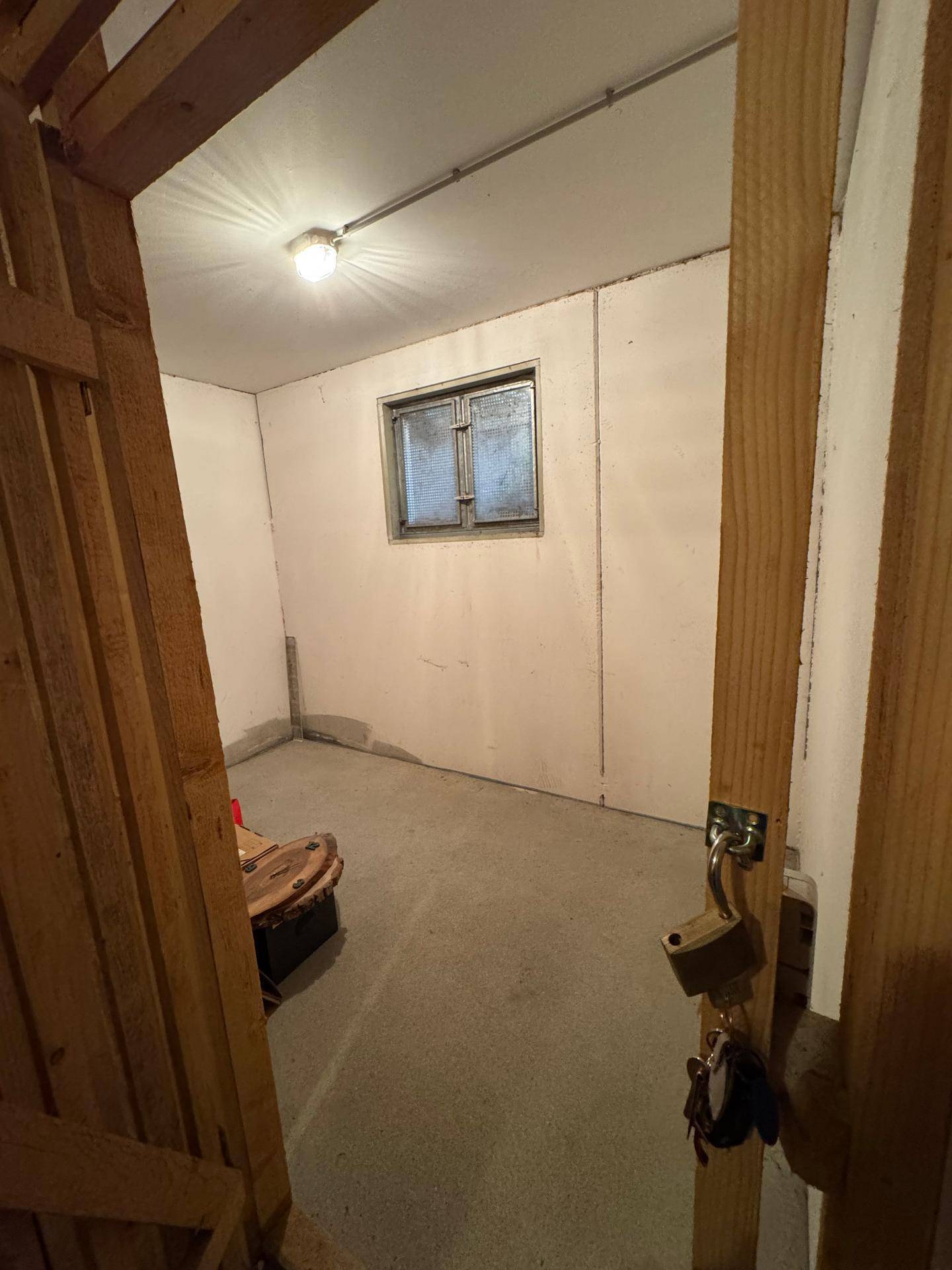 Kellerraum mit Betonboden, weiß gestrichenen Wänden und einem kleinen Fenster für Belüftung.